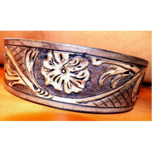 A Leather Band With Flower Design on a Orange Background