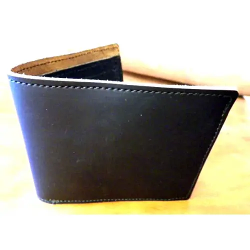 A Plain Black Color Single Fold Wallet Standing on a Surface